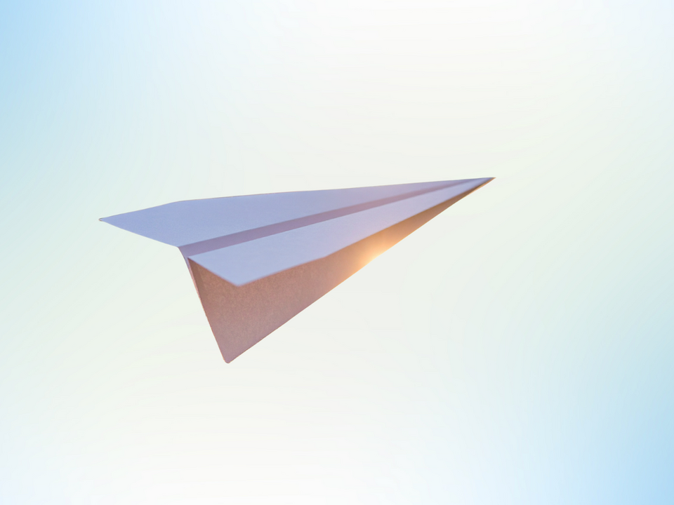 Papierflieger, fliegt vor blauem Himmel